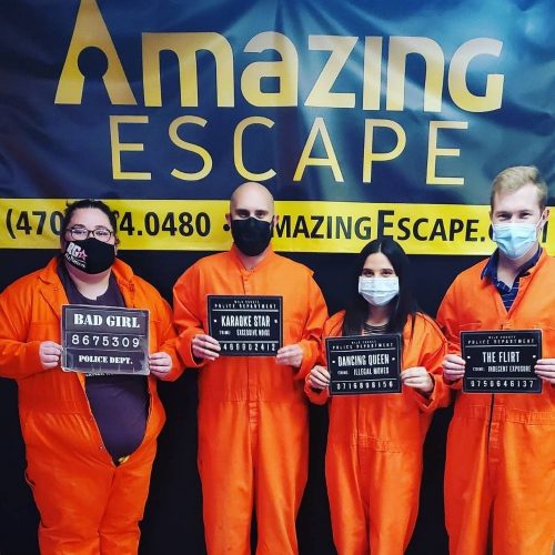 group of four people dressed as prisoners that just played the prison break escape game