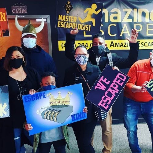 guys holding signs that they've escaped on of the challenges at Amazing Escape