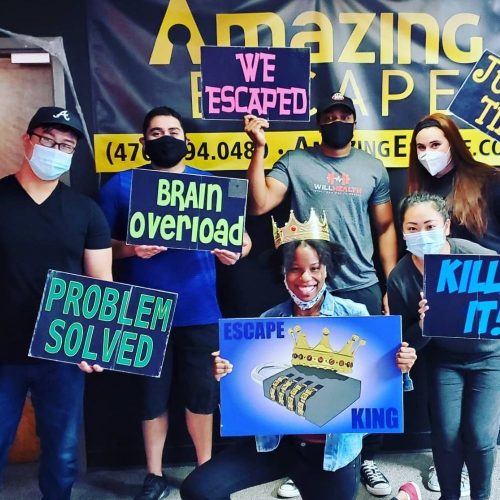 guys holding signs that say they've escaped the room